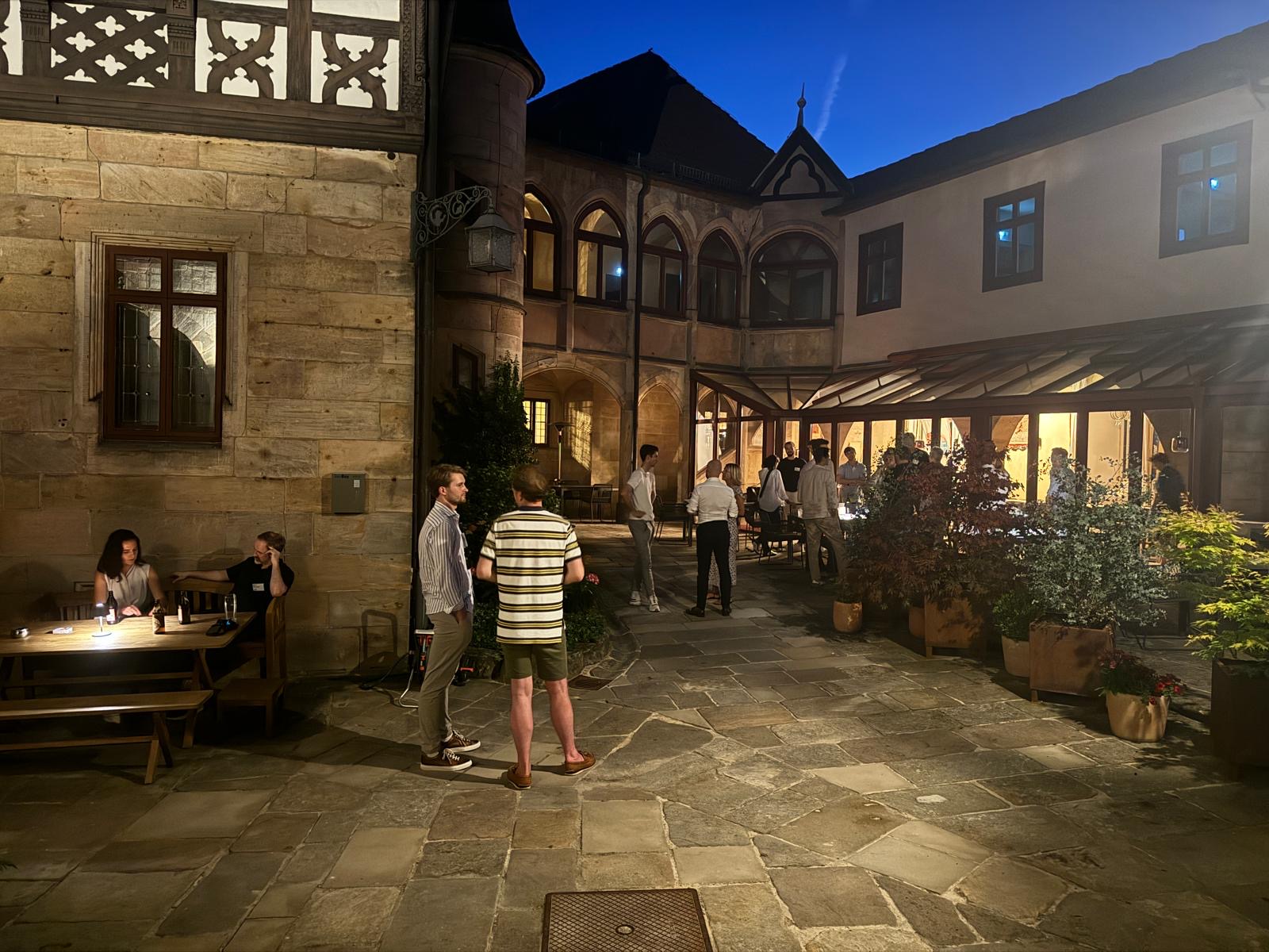 Abendlicher Austausch im Schlosshof – zwischen guten Gesprächen, neuen Ideen und leckerem Essen.